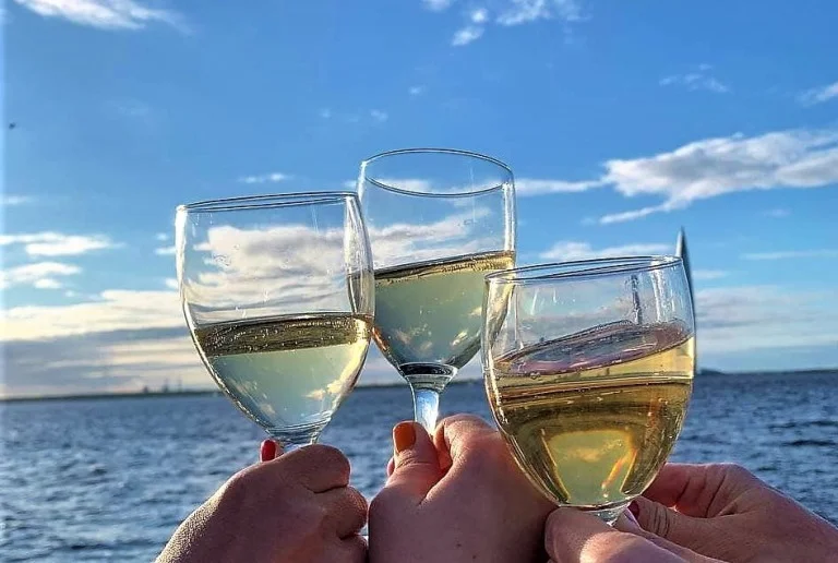 Три бокалы с белым вином на фоне моря