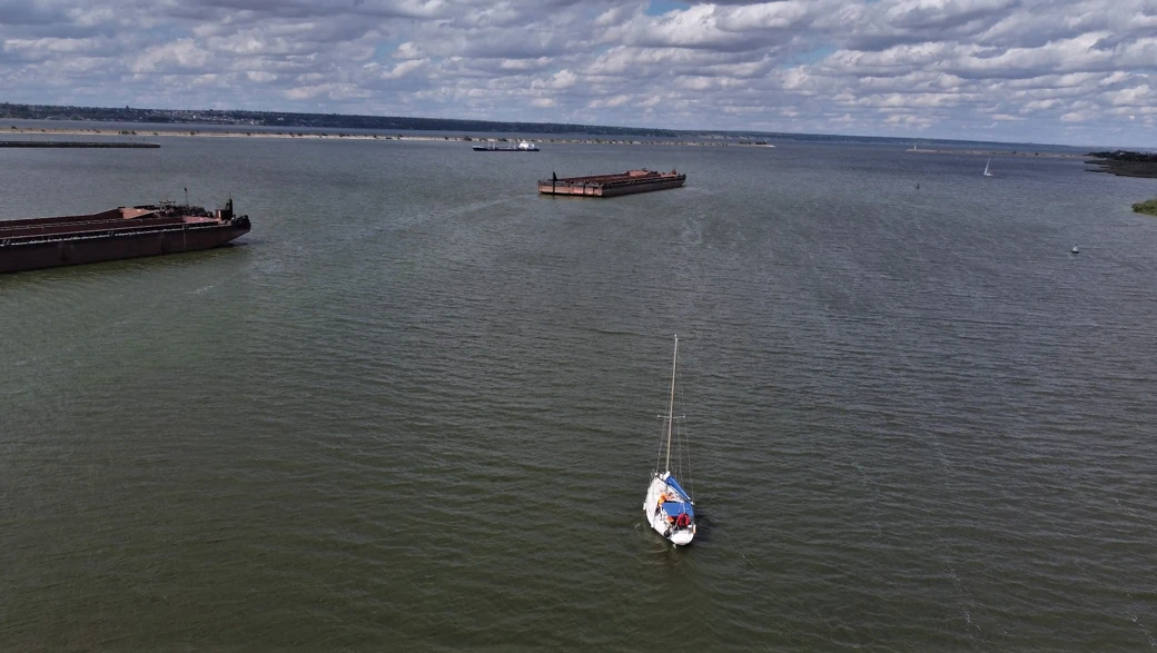Парусная яхта пересекает акваторию порта Волжский